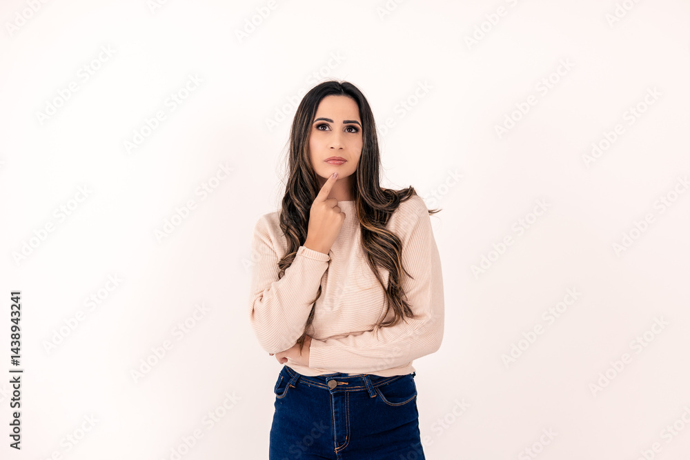jovem mulher pensativa, com mão no queixo em um fundo branco, cabelos escuros jovem mulher pensativa, com mão no queixo em um fundo branco, cabelos escuros