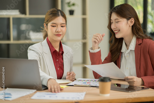 Asian businesswoman sitting at work using laptop talking and consulting in office
