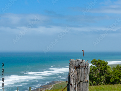 Obraz na płótnie Old fence post and wire in foreground to wide coastal land and sea scene w salonie