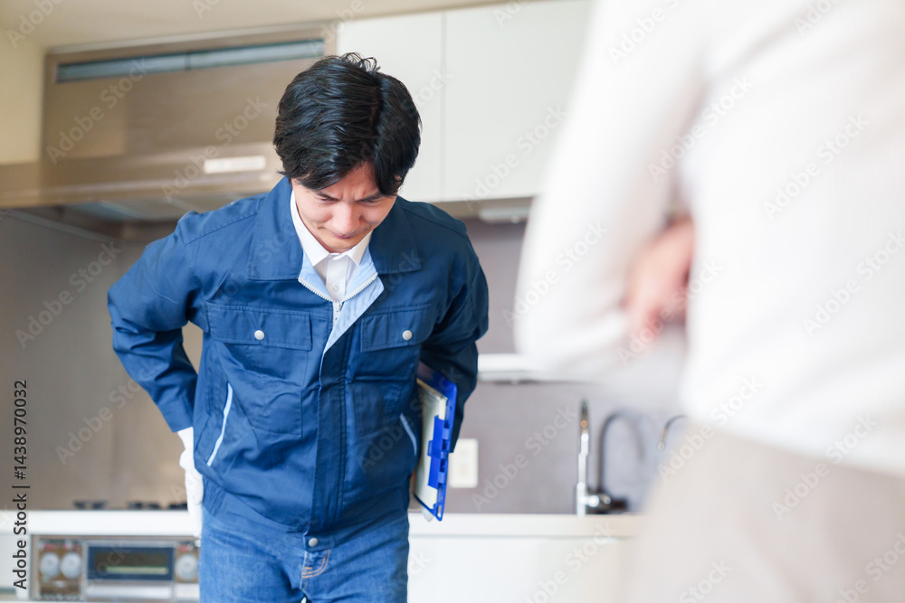 お客様に頭を下げてお詫びをする作業員の男性 お客様に頭を下げてお詫びをする作業員の男性