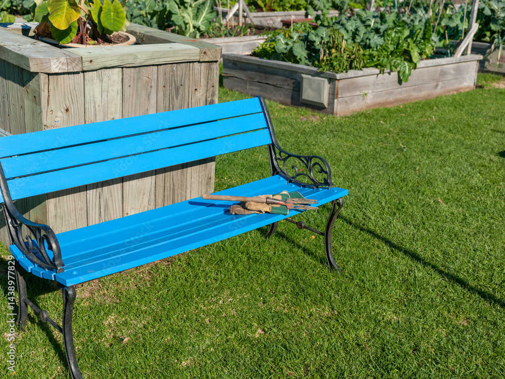 Blue bench seat with garden fork and glove at Otumoetai community gardens
