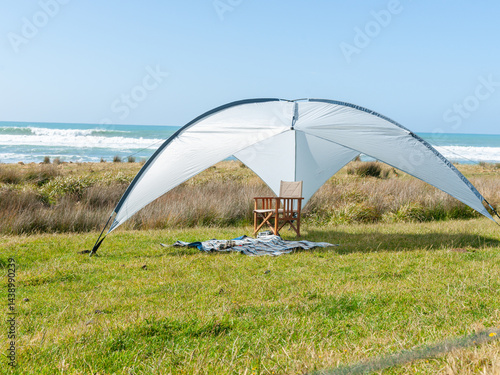 Obraz na płótnie Sunshade erected on grass with beach background w salonie