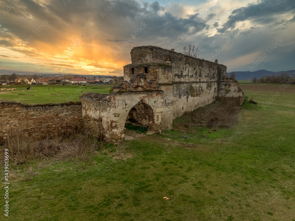 View of Alvinc Martinuzzi Castle ruin in Vintu de Jos, Transylvania Romania with colorful sunset