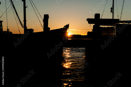 Obraz na płótnie Fisherman’s wharf commercial boast in silhouette back-lit by sunrise w salonie