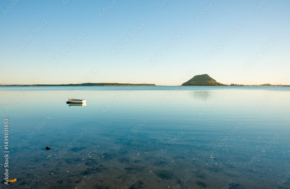 Tauranga harbour view to distant Mount Maunganui on horizon at sunrise.
