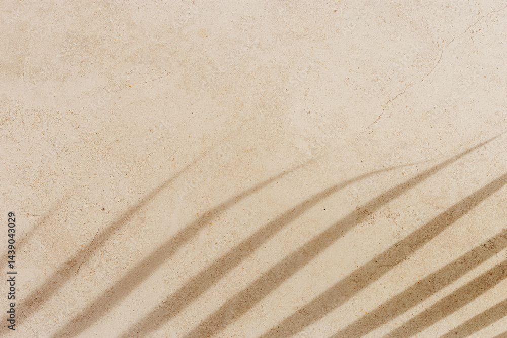 Soft shadows of tropical palm leaves on textured concrete background neutral beige colored. Summer travel, vacation, spa concept. Minimal style photography, summertime aesthetic backdrop copyspace