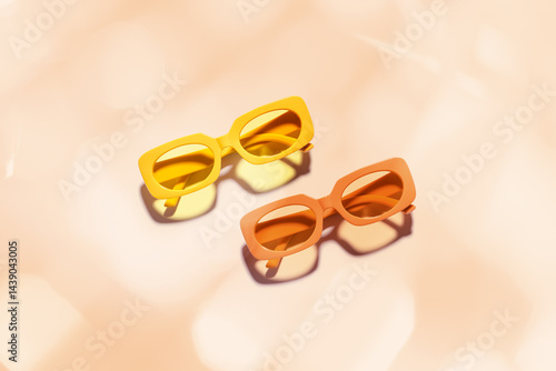 Obraz na płótnie Trendy sunglasses with Yellow and orange Frame on peach background, copyspace, beach vibes, summertime mood, sunlight shadow and glare, summer fashion glasses. Minimal top view of eyeglasses w salonie