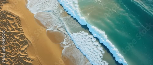 Aerial vista of sand dunes meeting turquoise ocean, a desert shoreline scenery