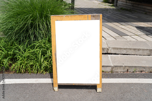 Obraz na płótnie Blank white outdoor advertising stand sandwich board mock up template. Clear street signage board placed by an outdoor dinning area of a restaurant. w salonie