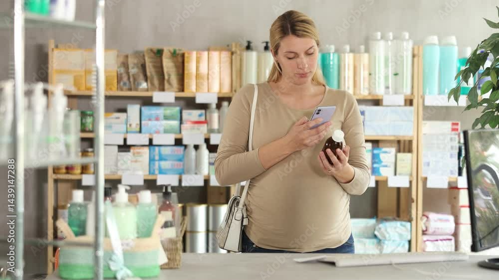 Pregnant woman in pharmacy scans QR code on medicine syrup product. High quality 4k footage Pregnant woman in pharmacy scans QR code on medicine syrup product. High quality 4k footage
