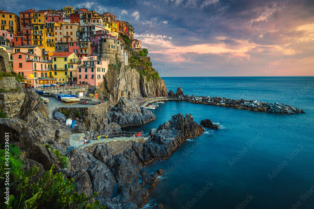 Village with colorful seaside houses on the cliffs at sunset