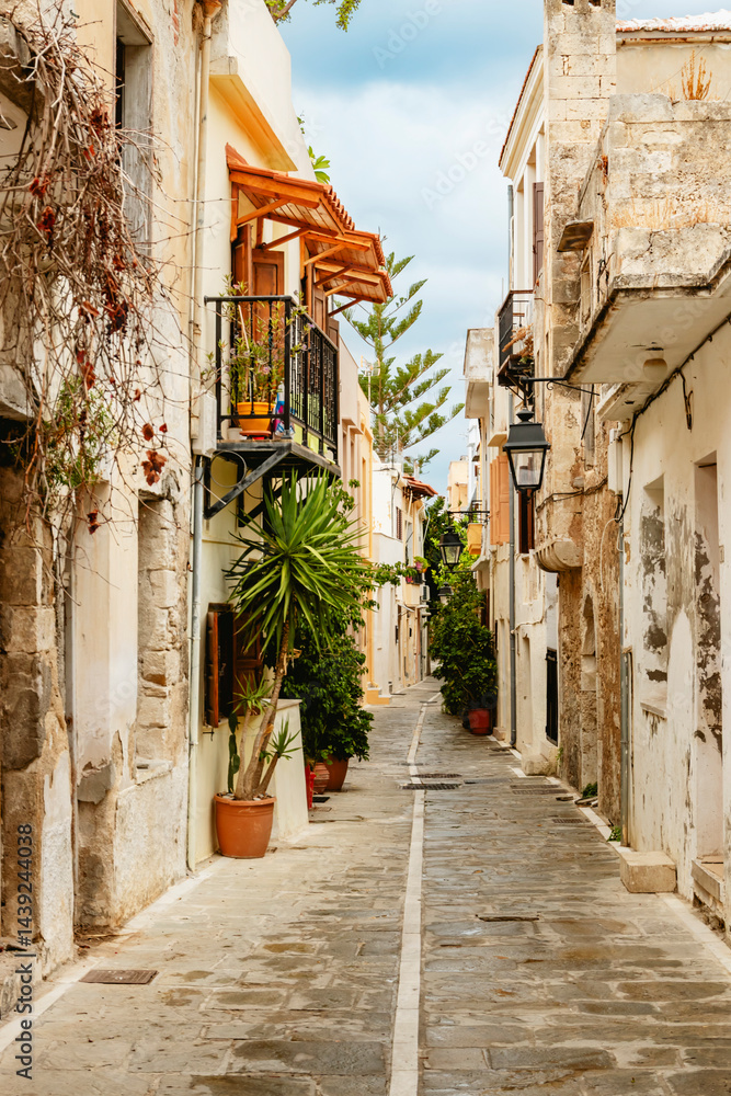A beautifully picturesque alleyway adorned with vibrant, lush bougainvillea situated in a serene village setting. Rethymno town, Crete island, Greece.