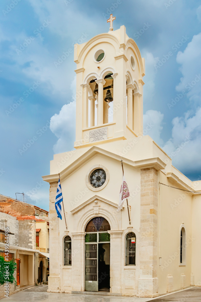 The stunning architecture of a magnificent Greek church featuring a beautiful bell tower set against a cloudy sky. Rethymno town, Crete island, Greece.
