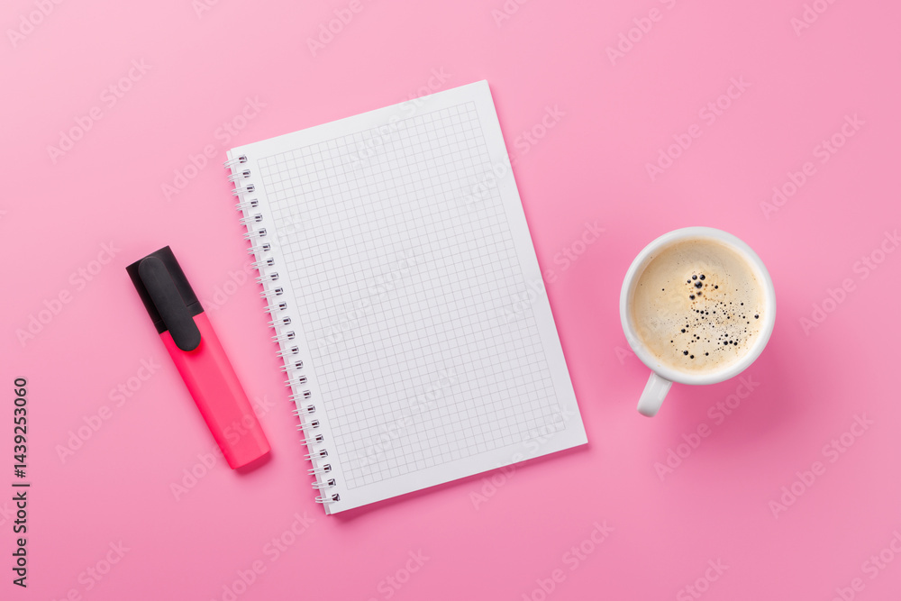 Top view of a pink desk with office supplies, coffee cup, and blank notepad Top view of a pink desk with office supplies, coffee cup, and blank notepad