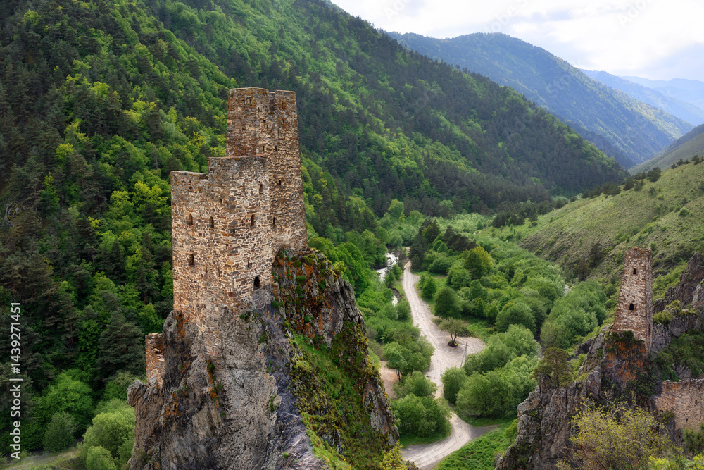 View from above of the Vovnushki tower complex and the road. Ingushetia - view of the mountains. View from above of the Vovnushki tower complex and the road. Ingushetia - view of the mountains.