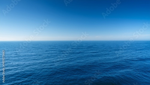 A clear blue ocean stretches to the horizon under a bright, cloudless sky.