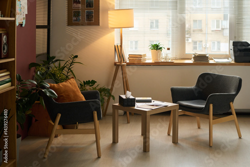 Obraz na płótnie Small square table with box of tissues, paper documents and notepad of psychologist standing between two armchairs in office w salonie