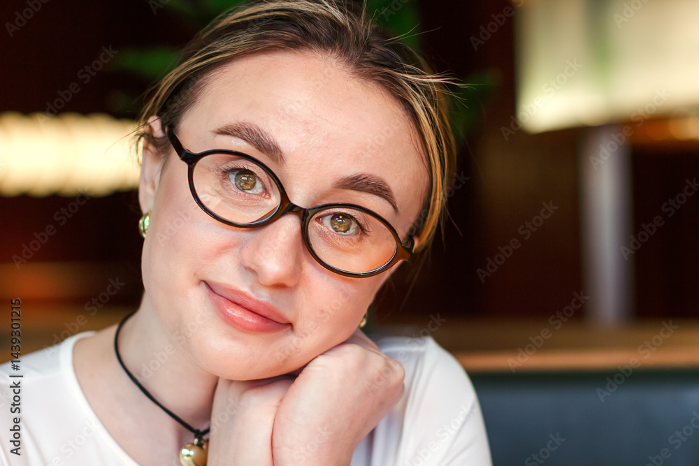 Portrait of a pretty girl in glasses looking at the camera