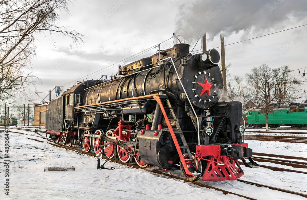 Obraz premium Vintage steam locomotive in winter at Darnytsia Depot in Kyiv, Ukraine