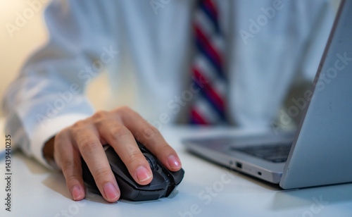 Close up hand of business man working on laptop computer by clicking on computer mouse on office desk,  searching in the internet, for information, online working at modern office. 