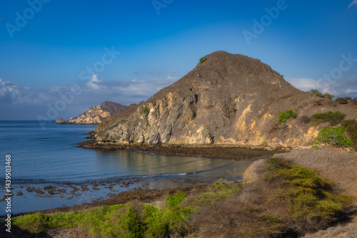 Wallpaper Mural The breathtaking coastal view showcases a stunning rocky hillside paired with calm waters, all beneath a perfectly clear blue sky that enhances its beauty Torontodigital.ca
