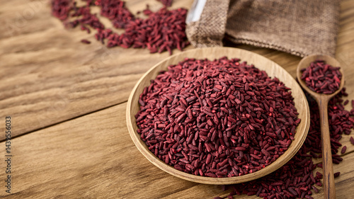 closeup pile of ferment red yeast rice or Angkak in wood bowl on wooden table rustic food background with copy space