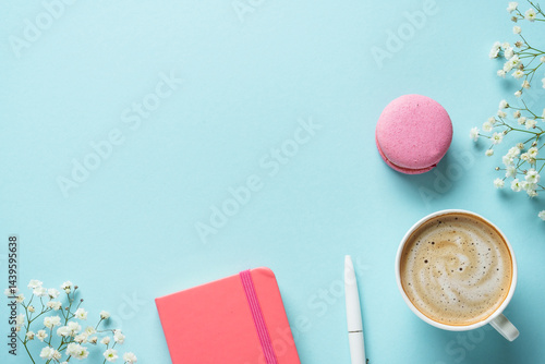 Obraz na płótnie Cup of coffee, macaroon and flower on blue background. Top view with copy space. w salonie