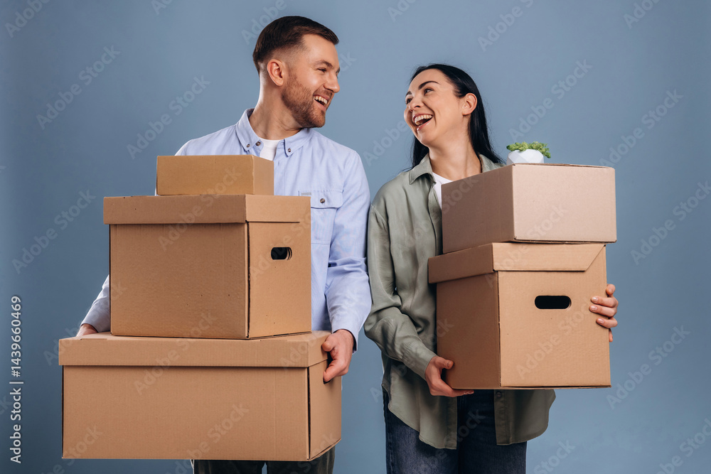 Positive, holding boxes, moving. Man and woman are in the studio Positive, holding boxes, moving. Man and woman are in the studio