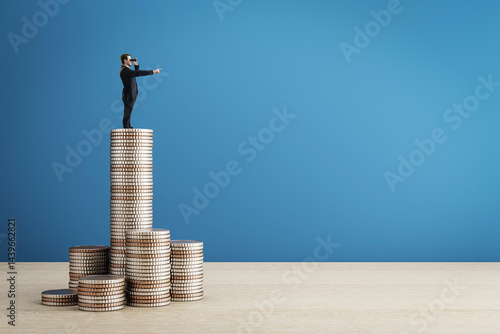 Konstfotografi Businessman standing on stacked coins looking ahead through binoculars, symbolizing financial vision and future investment planning