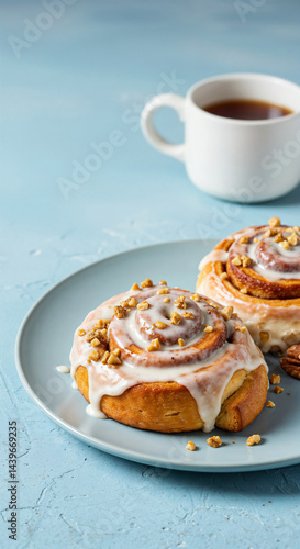 Cinnamon Rolls on Plate, Appetizing, Served with Tea, on Blue Textured Surface
