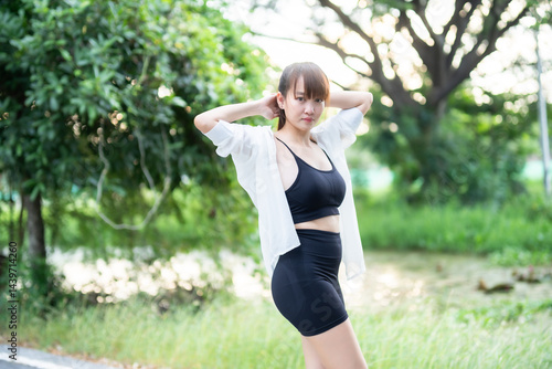 Obraz na płótnie Portrait of beautiful asian Young woman in Black robe sportswear working out outside. training on public equipment in outdoor at park. concept Exercise Healthy lifestyle. w salonie