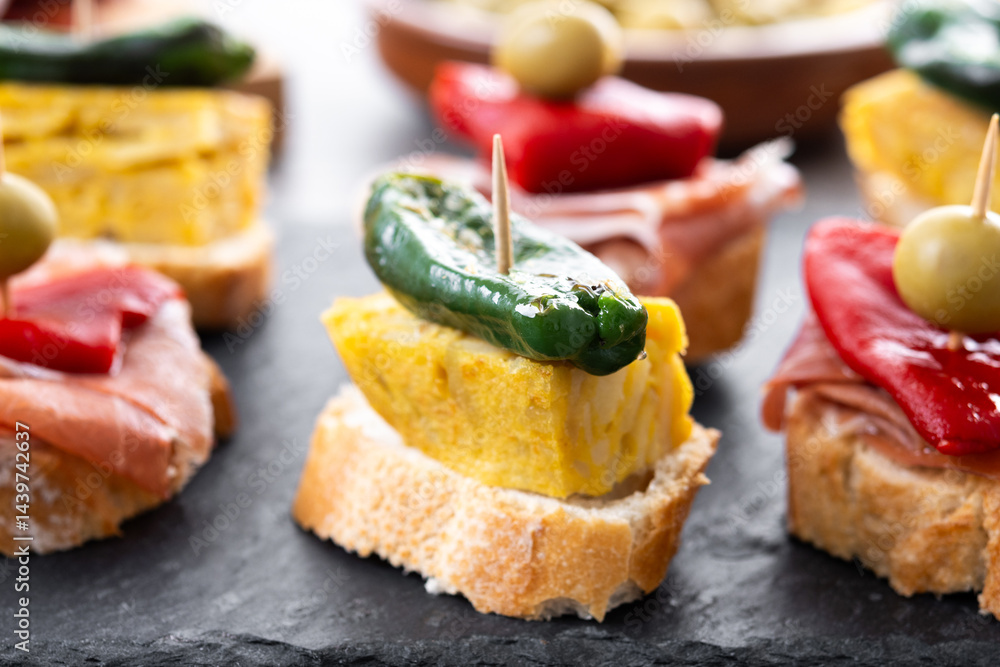 Traditional Spanish pintxos on wooden table Traditional Spanish pintxos on wooden table