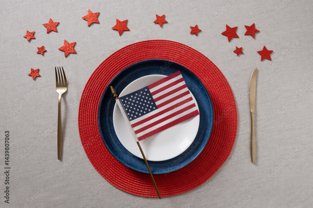American dinner or table setting for USA Independence Day. Festive dinner with empty white plate and decoration in USA national flag colors red and blue. View from above. Copy space.