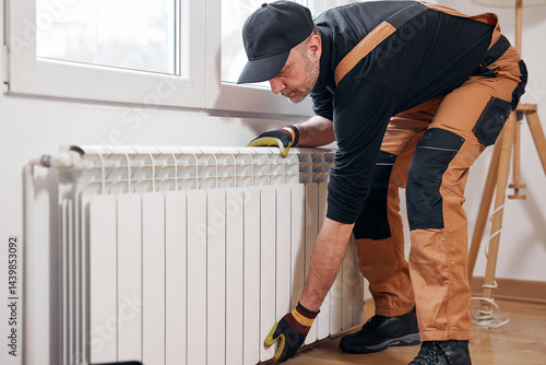 Obraz na płótnie Central heating mechanic and handyman fixing home radiator, gas crisis and seasonal issues. w salonie
