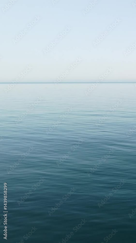 Vertical aerial view over calm azure sea water surface. Sun glare. Abstract nautical summer ocean nature. Holiday, vacation and travel concept. Nobody. Weather and climate change Vertical aerial view over calm azure sea water surface. Sun glare. Abstract nautical summer ocean nature. Holiday, vacation and travel concept. Nobody. Weather and climate change