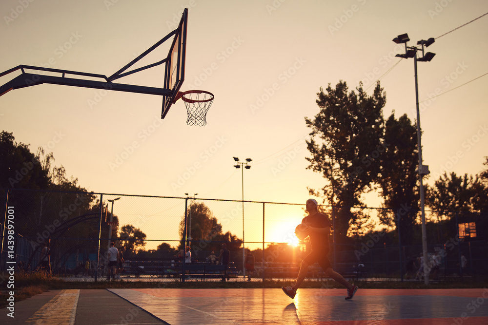 Man playing basketball on a public court.