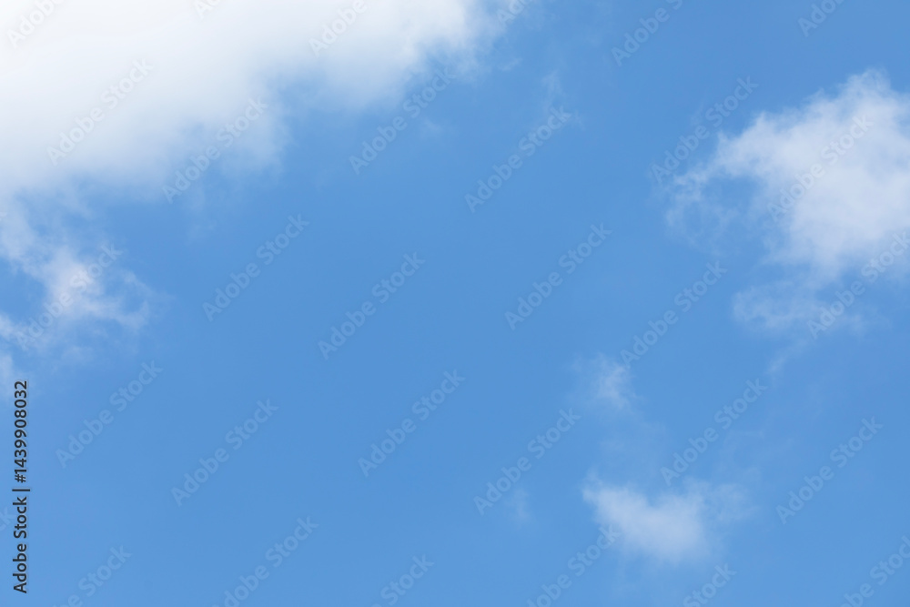Blue sky background and white clouds soft focus, space in the middle, horizontal shape.