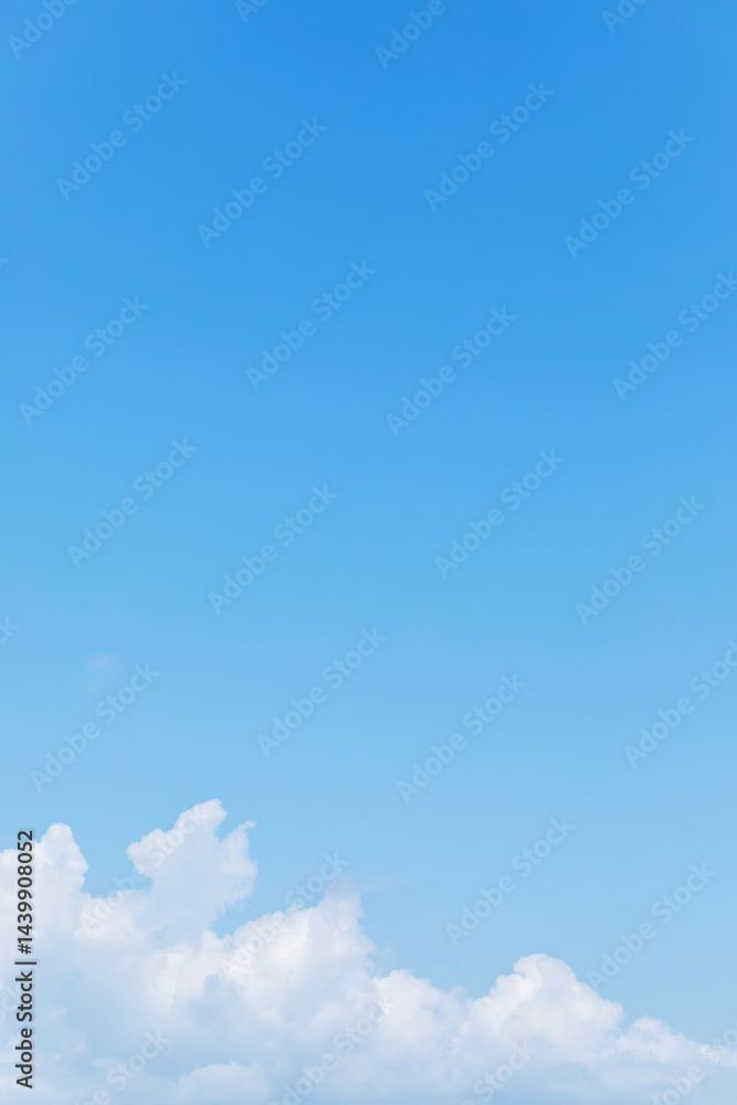 Blue sky background and white clouds soft focus, space in the middle, vertical shape.
