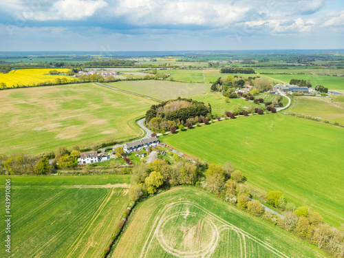Obraz na płótnie Aerial view of a small English hamlet showing a small number of terraced houses surrounded by prime agricultural land in Britain. w salonie