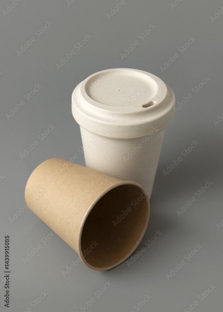 New beige kraft paper cups and reusable bamboo coffee cup with a lid on a gray closeup, mockup