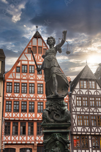Obraz na płótnie The Fountain of Justice in Frankfurt's Romerberg square, featuring Lady Justice, with colorful half timbered buildings in the background. w salonie