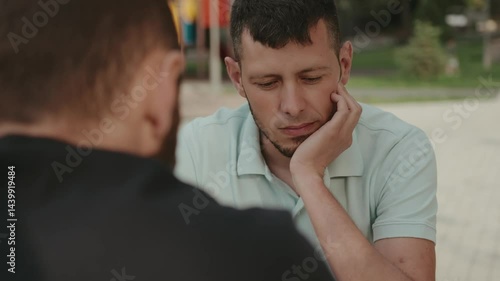 Two male friends sit together having a serious conversation. One friend is listening intently with a concerned expression. This video captures the emotions of friendship, empathy, and support.