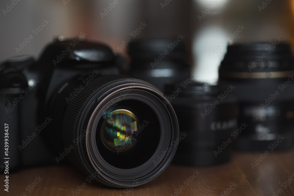 Close-Up of DSLR Camera Lens with Additional Lenses on Wooden Surface