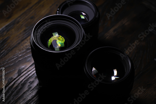 Obraz na płótnie Close-Up of Camera Lenses with Reflections on Wooden Surface w salonie