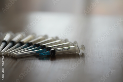 Close-up of Syringes on Wooden Surface Highlighting Medical Supplies and Vaccination