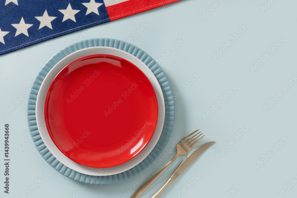 American table setting for USA Independence Day. Festive dinner with empty white plate and decoration in USA national flag colors red and blue. View from above. Copy space.