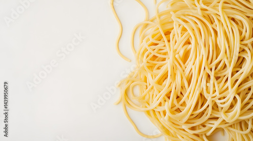A pile of spaghetti noodles arranged casually on a white background, emphasizing their long, thin shape and texture.