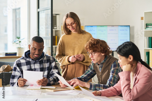 Group of diverse students engaging in language study sessions in classroom setting, collaborating and discussing. Bright, interactive environment fostering learning and teacher support