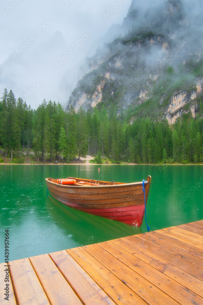 Boat on Lake Braies, Dolomites, Italy. Lake and reflections on the water surface. Mountain landscapes in summer. Place for mountain hiking, travel and vacation. Wallpaper, postcard, photo.