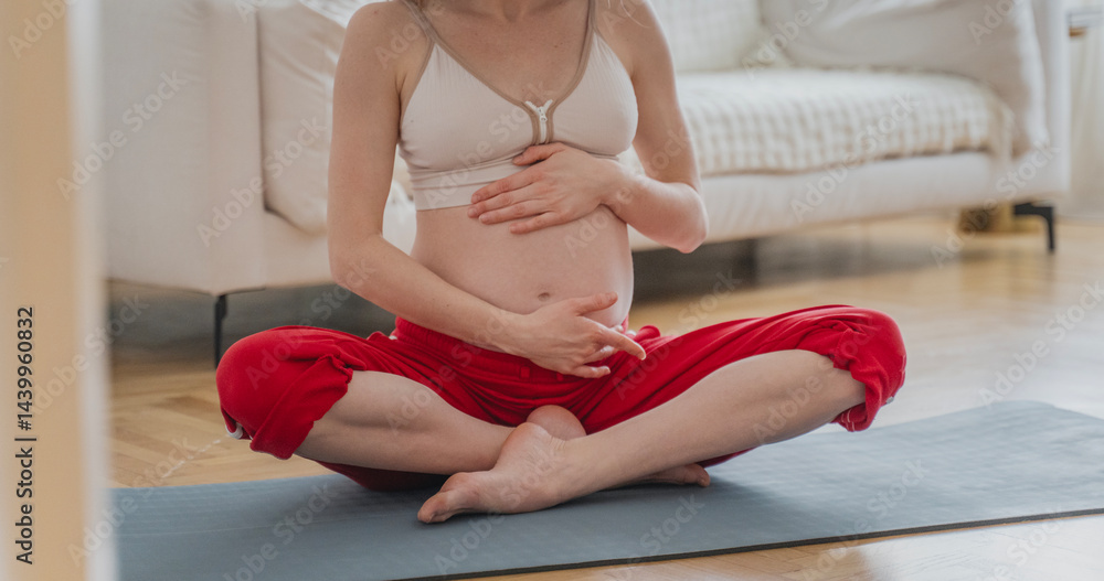 Young Caucasian pregnant woman doing yoga and meditation sitting in lotus position